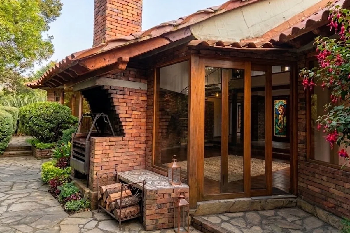 Zona de barbecue con chimenea de ladrillo y flores fucsias
