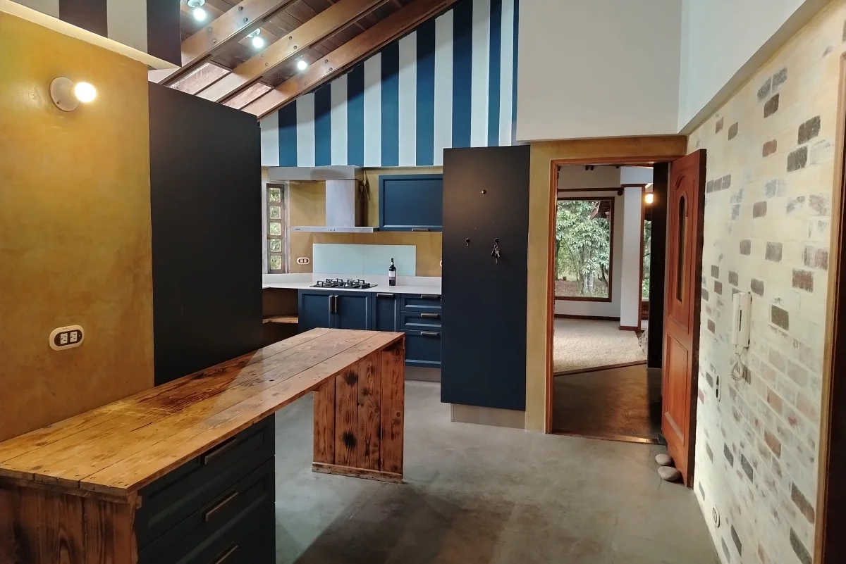 Cocina amplia con isla de madera y detalles en azul