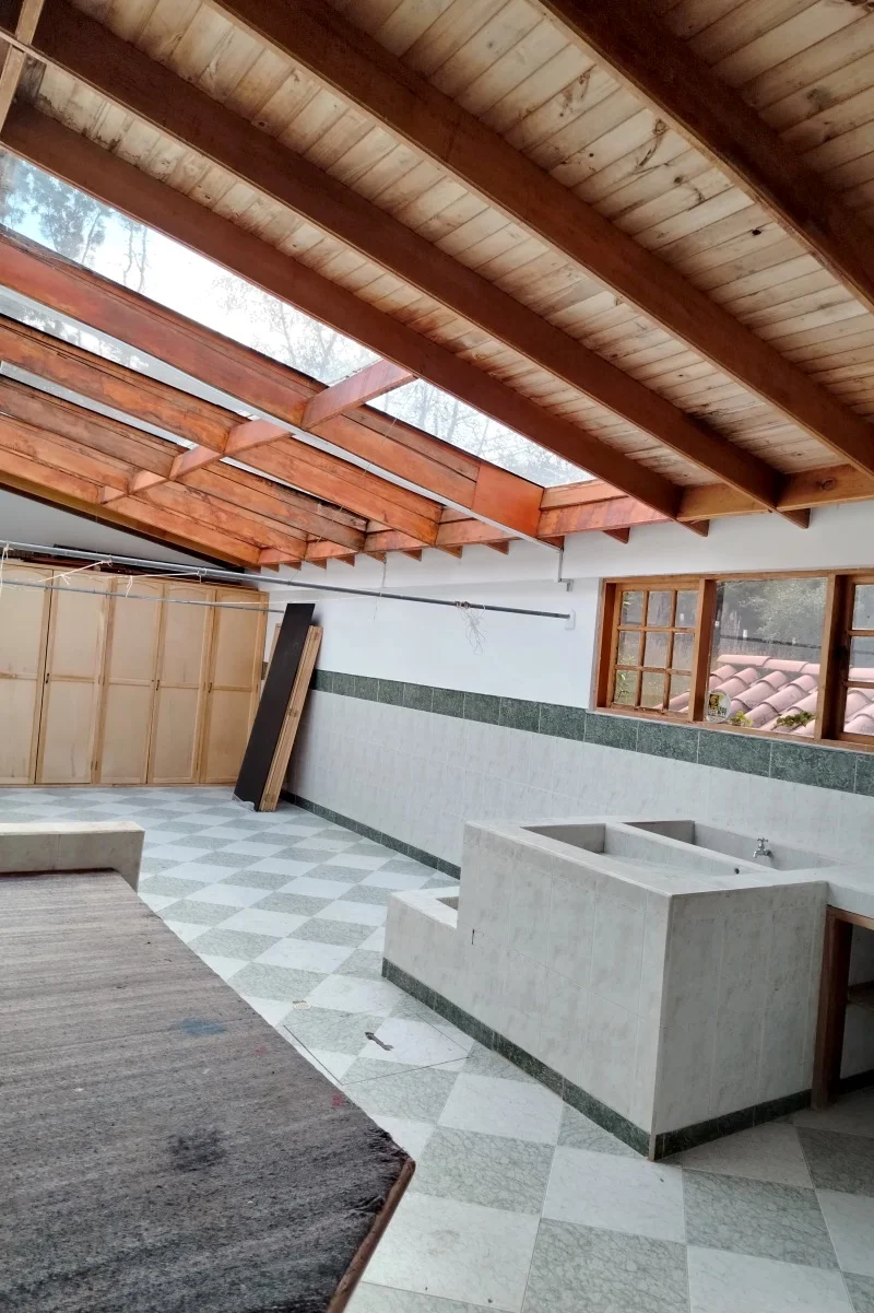 Patio interior con techo de vigas de madera y claraboyas